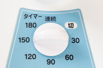 Analog timer device of a bule and white Japanese electric fan