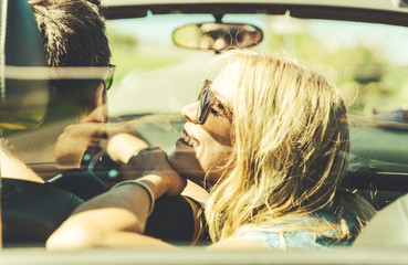 Couple romantic drive. Boy and girl sitting and driving on a sport car