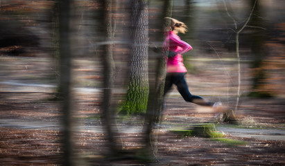 Young woman running outdoors in a city park on a cold fall/winte