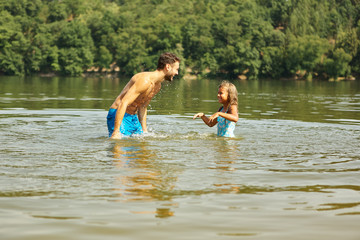 Vater hilft Tochter beim Schwimmen lernen