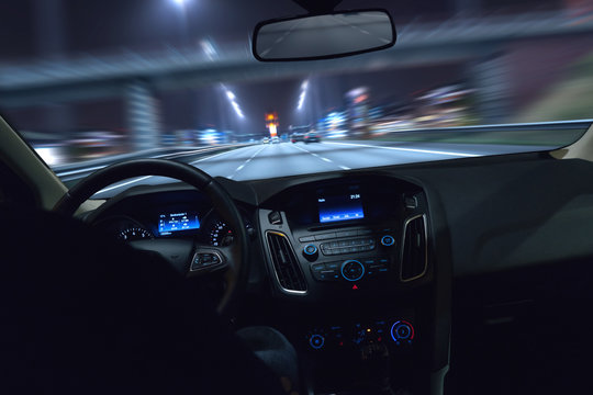 Auto f&auml;hrt bei Nacht durch eine Stadt
