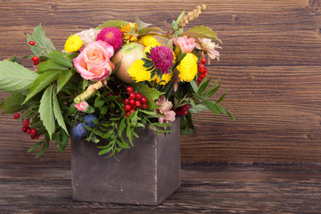 Amazing autumn bouquet with berries in a wooden vase