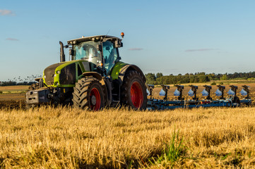 Obraz premium Agriculture plowing tractor on wheat cereal fields