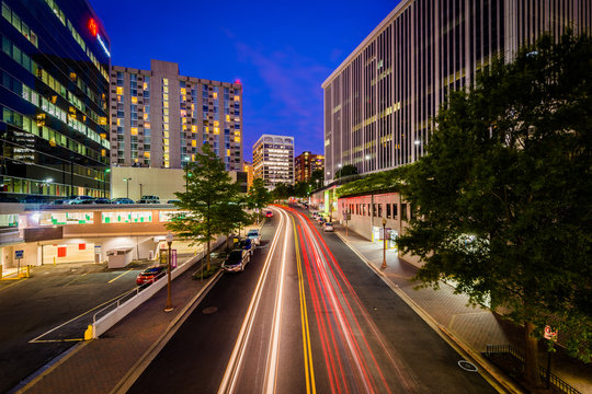 Traffic and modern buildings along Nash Street at night, in Ross