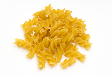 handful of pasta spirals on a white background