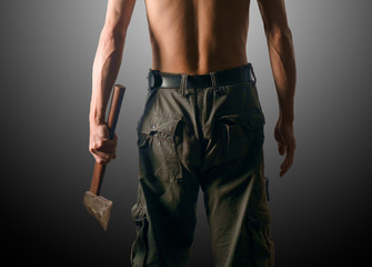 Man holding axe / Rear view of man holding axe on gray background. Dark tone.