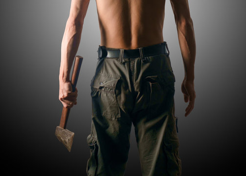 Man holding axe / Rear view of man holding axe on gray background. Dark tone.