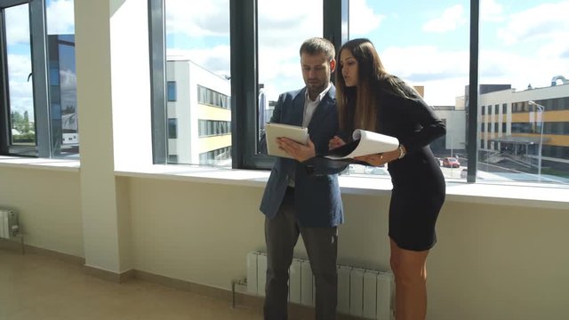 businesswoman and businessman standing in office and discuss the business plan
