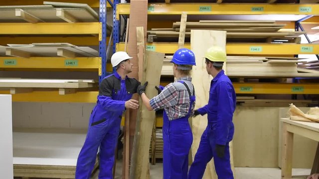 Students in carpentry apprenticeship carrying wood
