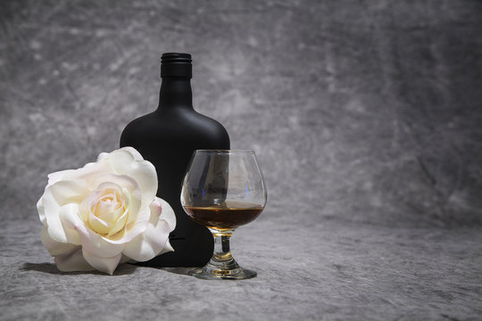 Black, White and Amber color on a rose, black brandy bottle and snifter