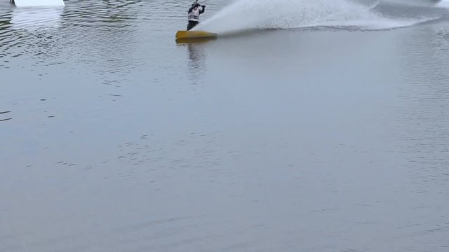 man on a wakeboard makes perfect landing after a jump. Complicated tricks. Professional skating. wakepark