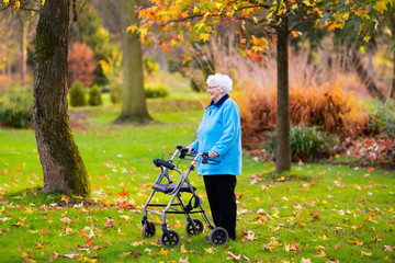 Senior lady with a walker in autumn park