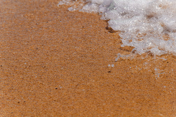 Small foam wave on sea close with beach