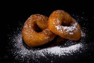 Sprinkling sugar powder on donut