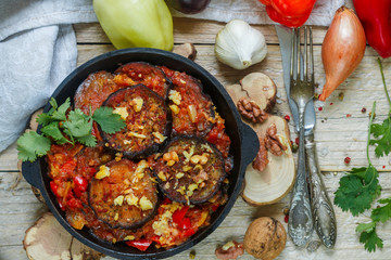 Baked eggplant with peppers, garlic, tomatoes and walnuts. Cold or hot appetizer. A rustic style. Selective focus. Top view


