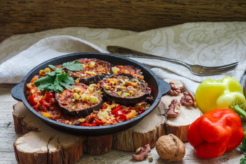 Baked eggplant with peppers, garlic, tomatoes and walnuts. Cold or hot appetizer. A rustic style. Selective focus
