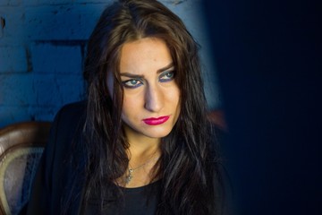 Fototapeta premium Девушка на кушетке на фоне кирпичной стены сексуальный образ красивые волосы