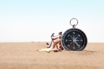 Compass, seashell on and starfish the sea sand