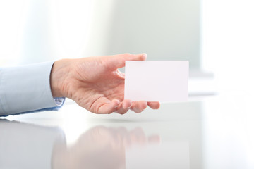 Hand hold blank business card, on desk