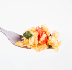 Risotto with chicken, tomatoes, bell pepper, onion, garlic and parsley on a fork on a white background 