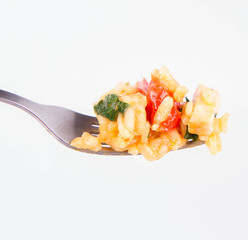 Risotto with chicken, tomatoes, bell pepper, onion, garlic and parsley on a fork on a white background 