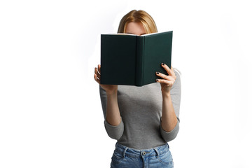 Beautiful young casual woman hiding herself behind a book isolated on white background