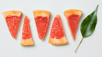 Slice of ripe grapefruit with leaves isolated