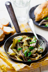 stewed celery with cepes in a vintage frying pan.