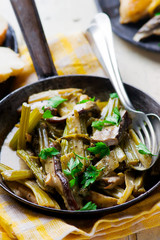 stewed celery with cepes in a vintage frying pan.
