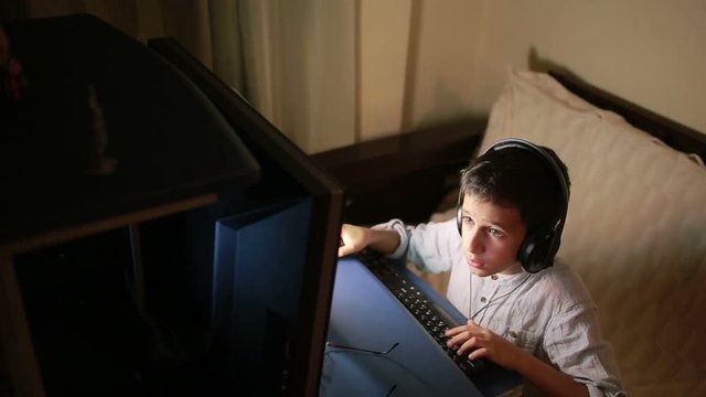 Teen boy plays games on the computer at night. Online Games