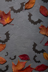 Halloween background with paper bats and autumn leaves. Top view with copy space