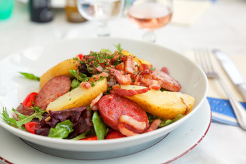 Gourmet salad with vegetables and fried ham served in a small be