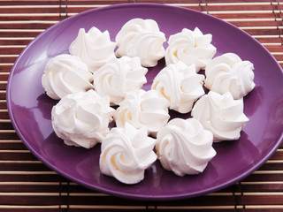 Meringues in a purple plate shot from above.