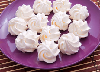 Meringues in a purple plate shot from above. Horizontal shot, cl