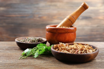 Natural flower and herb selection in  bowls on wooden background