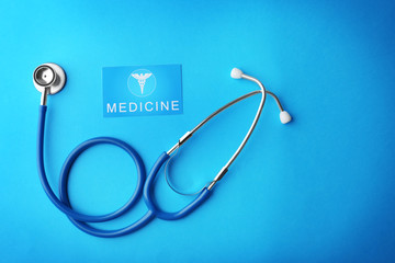 Stethoscope and card on blue background
