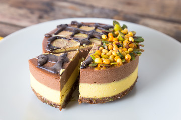 Raw vegan organic dessert with buckthorn, pistachio and chocolate, on a wooden background, close-up. 