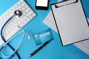 Stethoscope with keyboard, card and clipboard on blue background