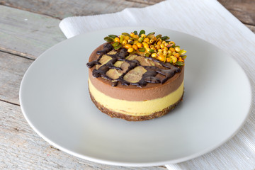 Raw vegan organic dessert with buckthorn, pistachio and chocolate, on a wooden background