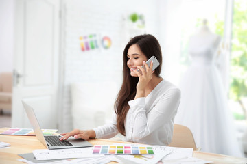 Pretty young dress designer at workplace