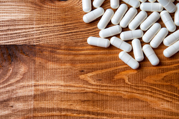 Creatine tablets on a wooden table