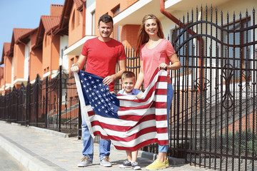 Fototapeta premium Happy family with American flag in the yard