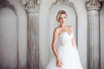 Fototapeta premium Charming young bride in luxurious wedding dress. Pretty girl, the photo Studio