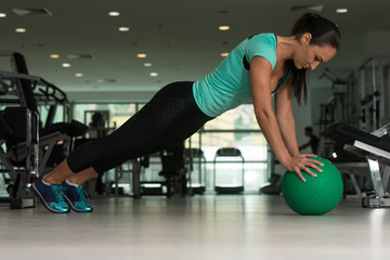 Attractive Woman Doing Push-ups On Floor In Gym