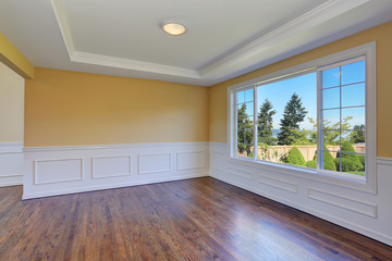 Obraz premium Empty room interior with yellow walls and hardwood floor