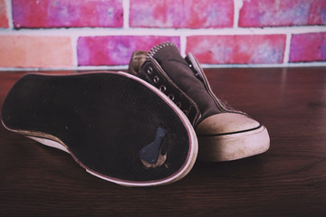 Old canvas shoes on a wooden floor Vintage Retro Filter.
