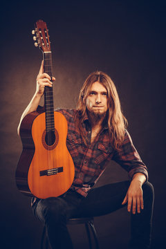 Guitarist is posing with guitar.