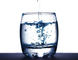 water splashing from glass on white background