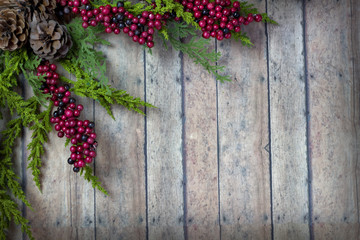 Christmas Garland with Pine Cones and Berries on a wood plank bo