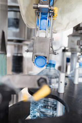 Water factory - Water bottling line for placing the cap on the bottles. 